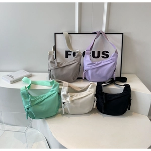 Détail de sacs à bandoulière en croissant en nylon de différentes couleurs avec zips