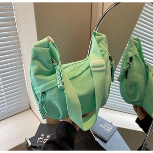Vue détaillée du sac croissant en nylon vert menthe avec sangle tissée et boucle en plastique