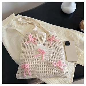 Handmade cream woven tote bag featuring decorative pink knit bows and openwork pattern