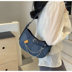 Hobo-Tasche aus blauem Denim mit Silberkette und Vintage-Schnalle an einem Model