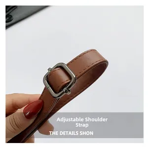 Macro detail of brown leather adjustable shoulder bag strap with dark gunmetal buckle