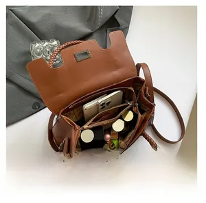 Detail view of the brown leather shoulder bag interior with multi-compartment storage space