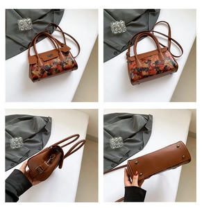 Detailed close-up showing woven handle, metal lock, and bottom studs of the vintage floral bag