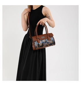 Detail of trendy crossbody bag with brown leather, graffiti print and woven handle