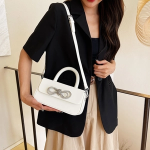 Elegant cream white shoulder bag with rhinestone bow detail for evening and formal wear