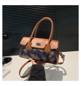 Detail of vintage patchwork handbag with woven handle and purple floral texture