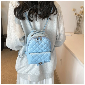 Dettaglio mini zaino trapuntato azzurro con tracolle a catena sulla modella