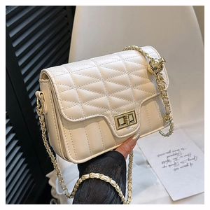 Detail of white quilted leather handbag with gold chain strap and metal ball charm