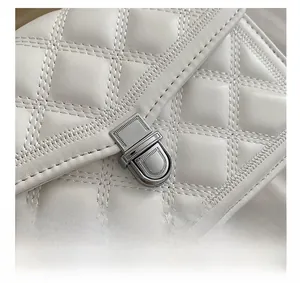 Detail shot of white quilted leather texture and silver metallic rotating twist lock