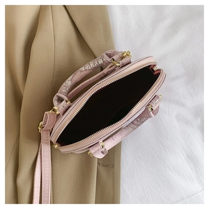 Detailed top view of pink shell bag showing spacious interior and golden zippers