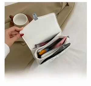 Interior view of white quilted crossbody bag showing multiple storage compartments