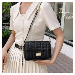 Elegant black quilted crossbody bag with gold chain strap and metal turn-lock closure