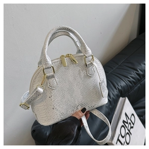 Detail of silver shell bag showing snakeskin texture and golden metallic zippers
