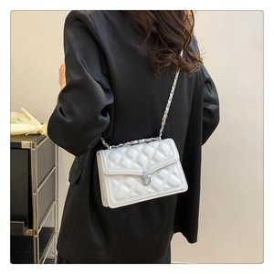 White quilted crossbody bag with silver chain strap shown from a back side angle view