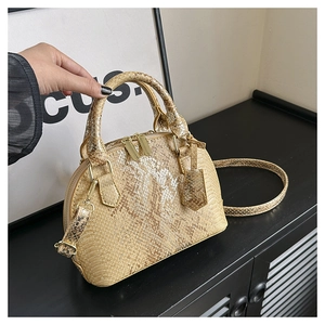 Detailed macro of golden snakeskin shell bag with luxury metallic texture and hardware