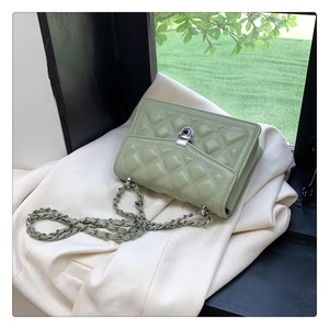 Detailed close-up of mint green quilted crossbody bag with silver chain and metal lock