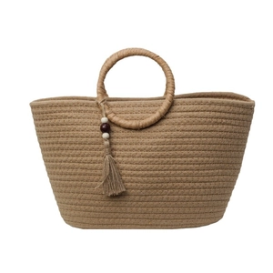 Minimalist woven handbag with round handle and tassel bead charm on a clean white background