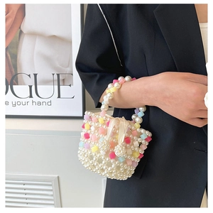 Close-up of handmade pearl crossbody bag with colorful beads and beige satin bow detail