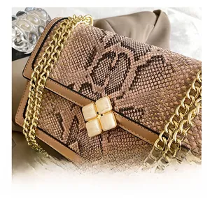 Close-up of brown snakeskin texture handbag with gold flower metal clasp and chain