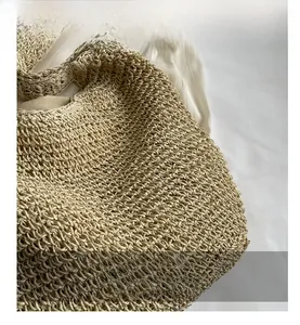 Detail view of beige woven handbag showing texture and intricate hollow knit craftsmanship