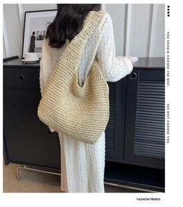 Detailed texture of a beige crochet straw tote bag worn as a casual shoulder handbag
