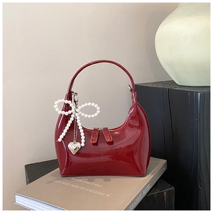 Borsa a mezzaluna in pelle verniciata rossa lucida con fiocco di perle e ciondolo cuore