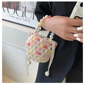 Handmade colorful beaded pearl handbag with satin ribbons shown against a black blazer