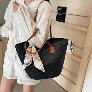Large black woven tote bag with brown leather straps and floral silk scarf detail