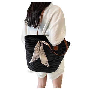 Black woven straw tote bag with brown leather straps and bamboo pattern ribbon decoration