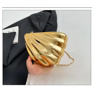 Detail of golden shell-shaped evening bag with pleated metallic texture and chain