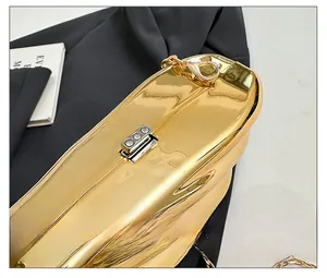 Close-up of golden shell clutch bag featuring silver hardware buckle with three sparkling diamonds