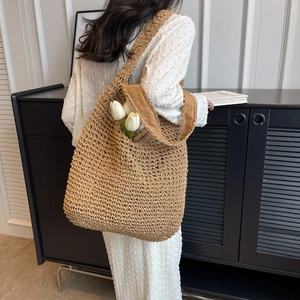 Handwoven straw tote bag in tan with wide shoulder strap and spacious interior for women
