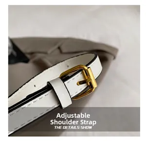 Close-up of white leather adjustable strap with glossy gold buckle and white stitching