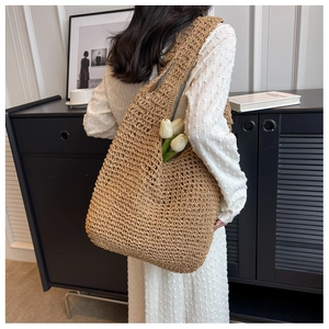 Handwoven straw tote bag in natural brown featuring a hollow lattice pattern for women