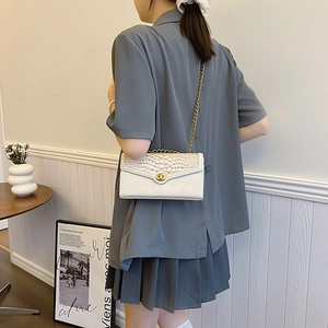 Elegante borsa bianca con trama a coccodrillo, catena dorata e chiusura girevole