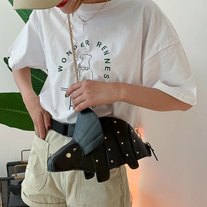 Black triceratops dinosaur crossbody bag with gold studs and chain strap on a model
