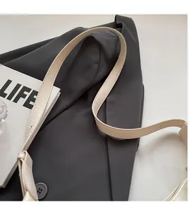 Detail of adjustable cream leather shoulder strap with smooth texture and multi-hole buckle