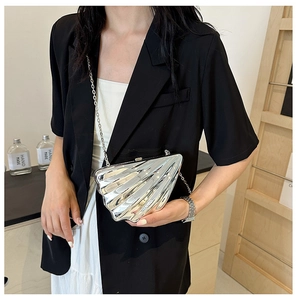 Silver shell-shaped metallic crossbody bag with chain strap shown on model for party style