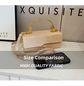 Size comparison of beige crocodile pattern handbag with gold handle and smartphone