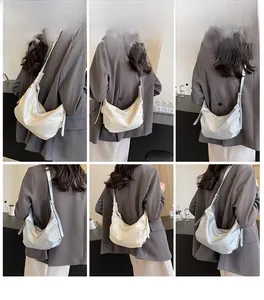 Model showcasing minimalist dumpling bag in beige and silver with adjustable wide strap