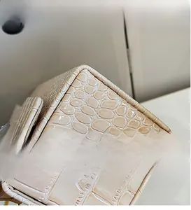 Close-up detail of high-quality crocodile pattern embossed leather on a beige luxury bag