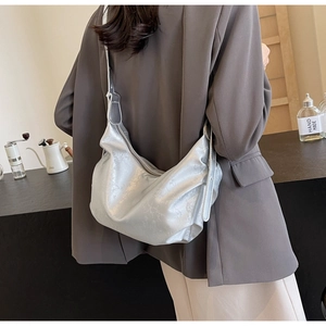 Detail of silver metallic hobo bag with cracked texture and adjustable wide shoulder strap
