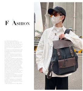 Detailed view of casual canvas backpack with brown leather flap and magnetic buckle closure