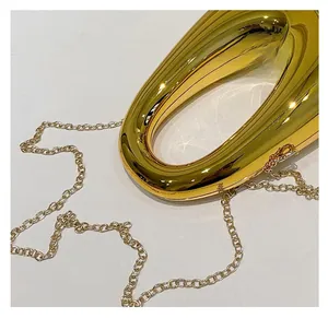 Detailed macro shot of the polished gold metallic handle and detachable chain link strap