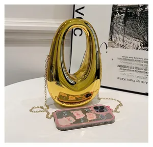 Detailed macro view of gold mirror finish handbag featuring an oval hollow cutout design