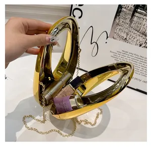 Detail view of gold circular clutch bag showing interior space for lipstick and makeup