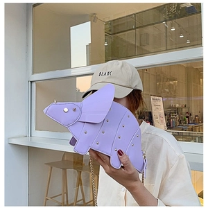 Light purple dinosaur cross-body bag with gold rivets and chain strap on a model