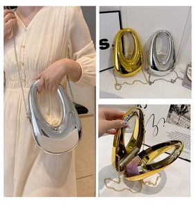 Detail view of mirror finish acrylic clutch with chain strap and compact interior space