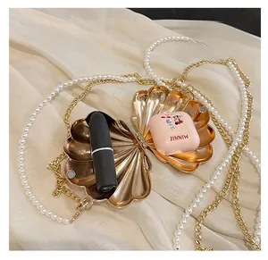 Internal view of shell evening bag showing space for lipstick and wireless earphones