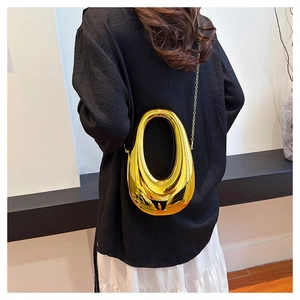 Close-up of a gold metallic oval hollow handbag featuring a sleek mirror finish and chain
